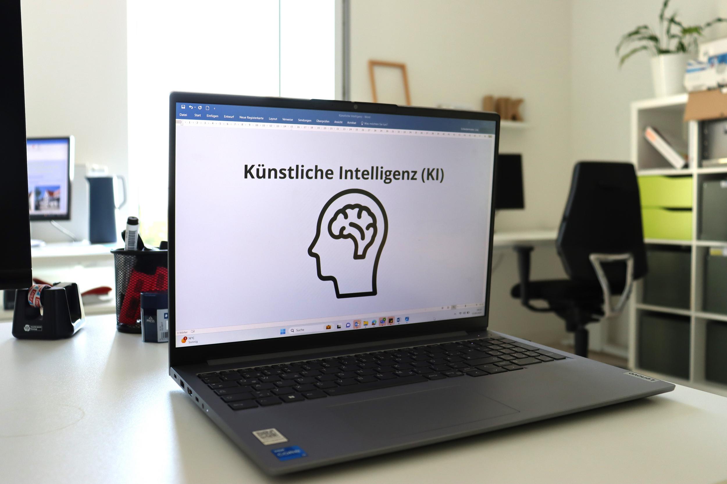 Bild von einem Laptop mit dem Schirftzug Künstliche Intelligenz und einem Kopf mit Gehirn